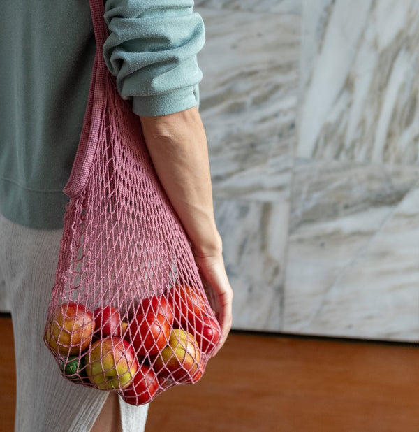 Rezginė sietka pirkinių krepšys rausvos spalvos, su vaisiais viduje, ant peties, detalė, dovanų idėjos, mados aksesuarai moterims